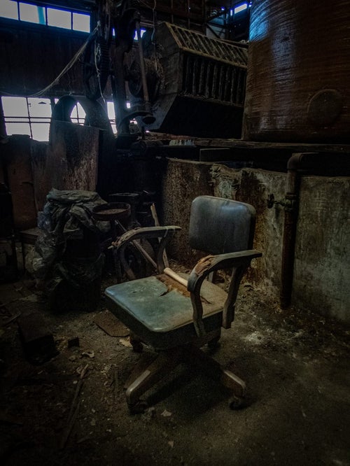 廃墟に残された椅子の写真