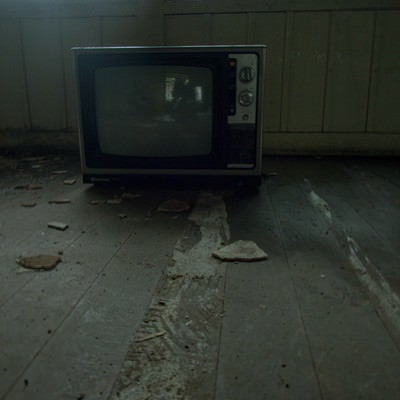 廃屋にぽつんと置かれた古いカラーテレビの写真
