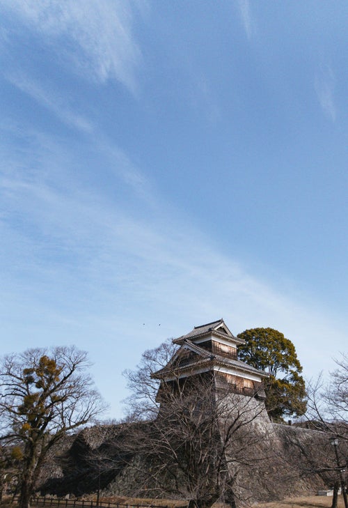 青空を流れる雲と熊本城内の櫓の写真