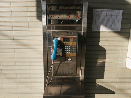 台湾の駅前に設置された古い電話ボックスの写真