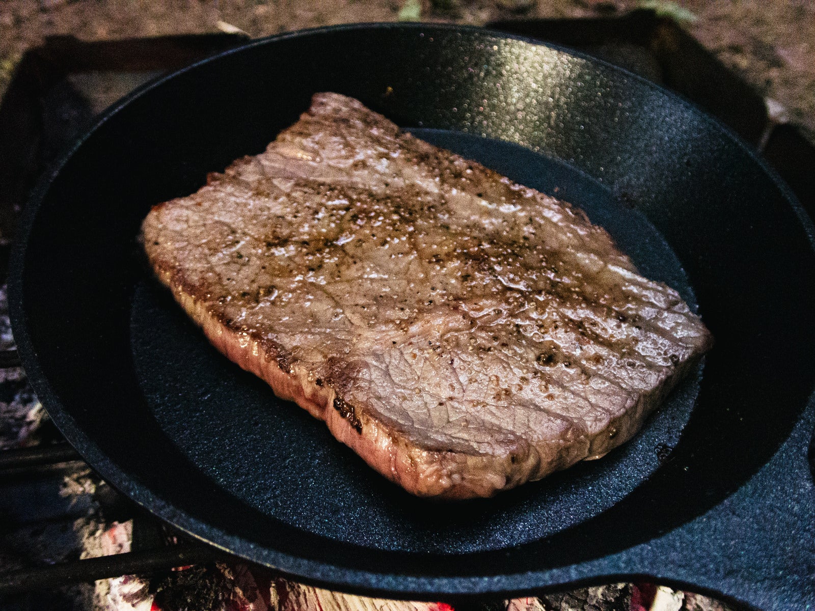 「フライパンで焼いた分厚い肉」の写真