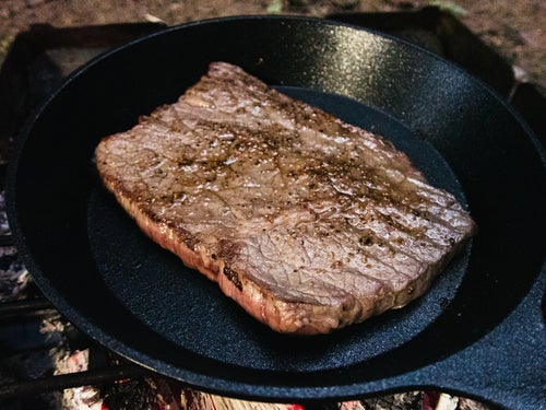 フライパンで焼いた分厚い肉の写真