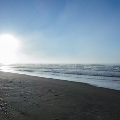 打ち寄せる波と夏の日差しの写真
