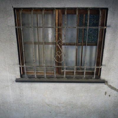 鉄格子のはまった古い小窓の写真