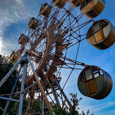 青空の下に静かに佇む錆びついた観覧車の素材