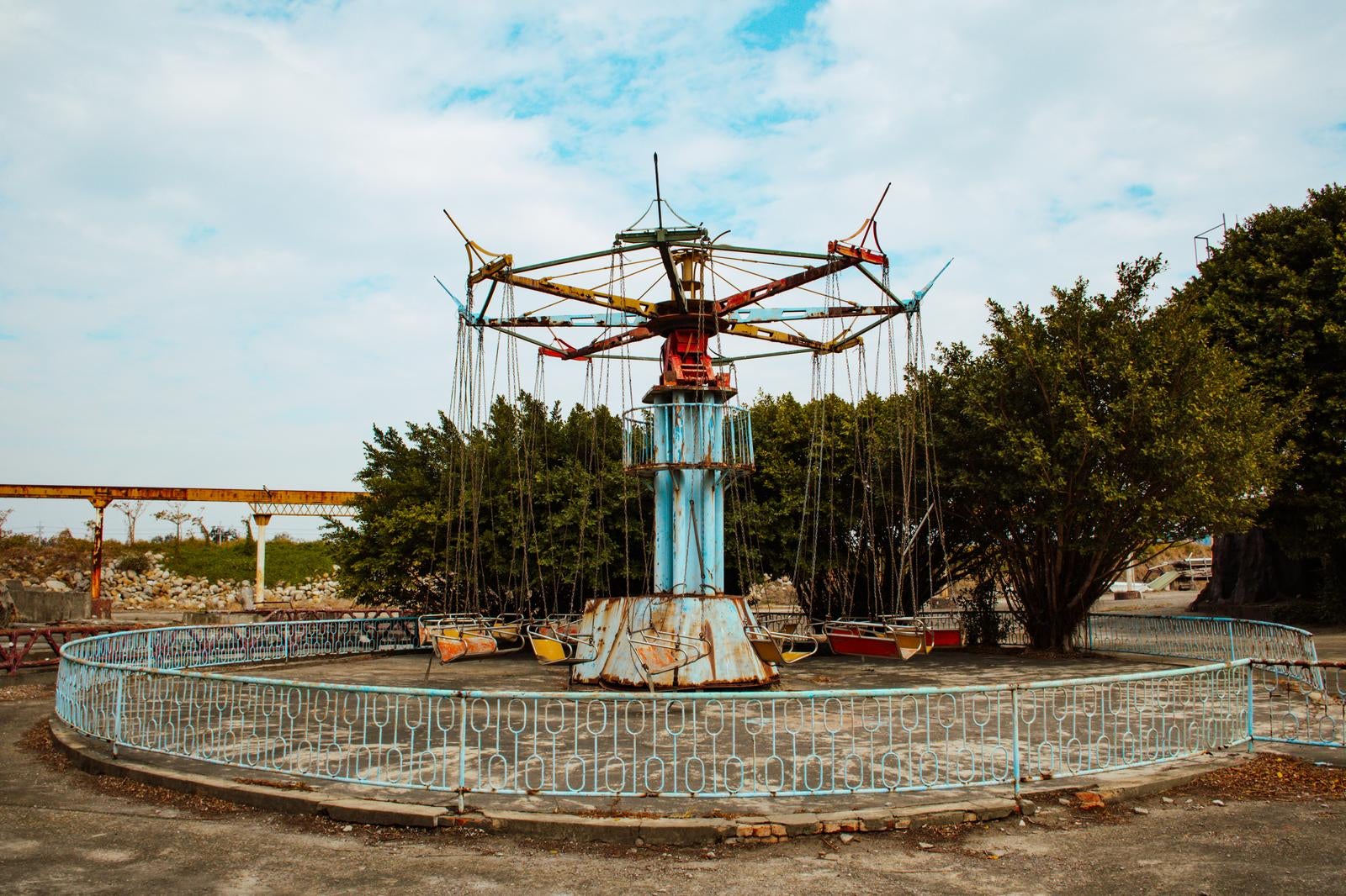 「廃墟となった遊園地の錆びた回転ブランコ」の写真