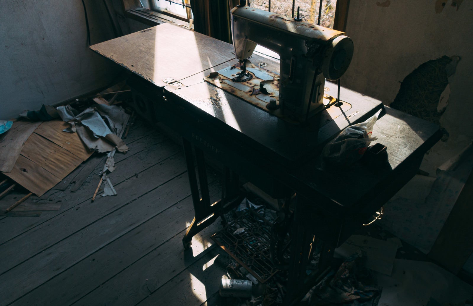 「窓から差す光とミシンの残骸」の写真