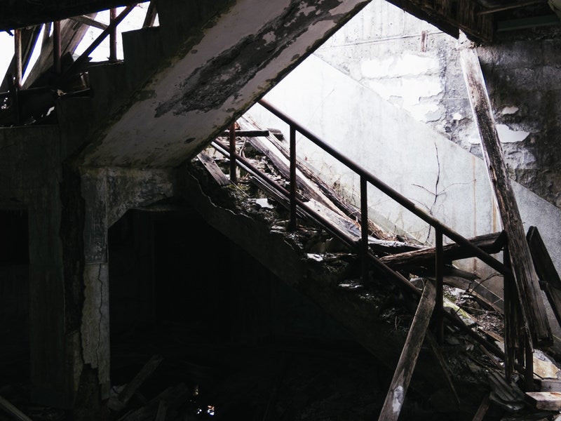 剥き出しの階段と崩れ落ちた柱の写真