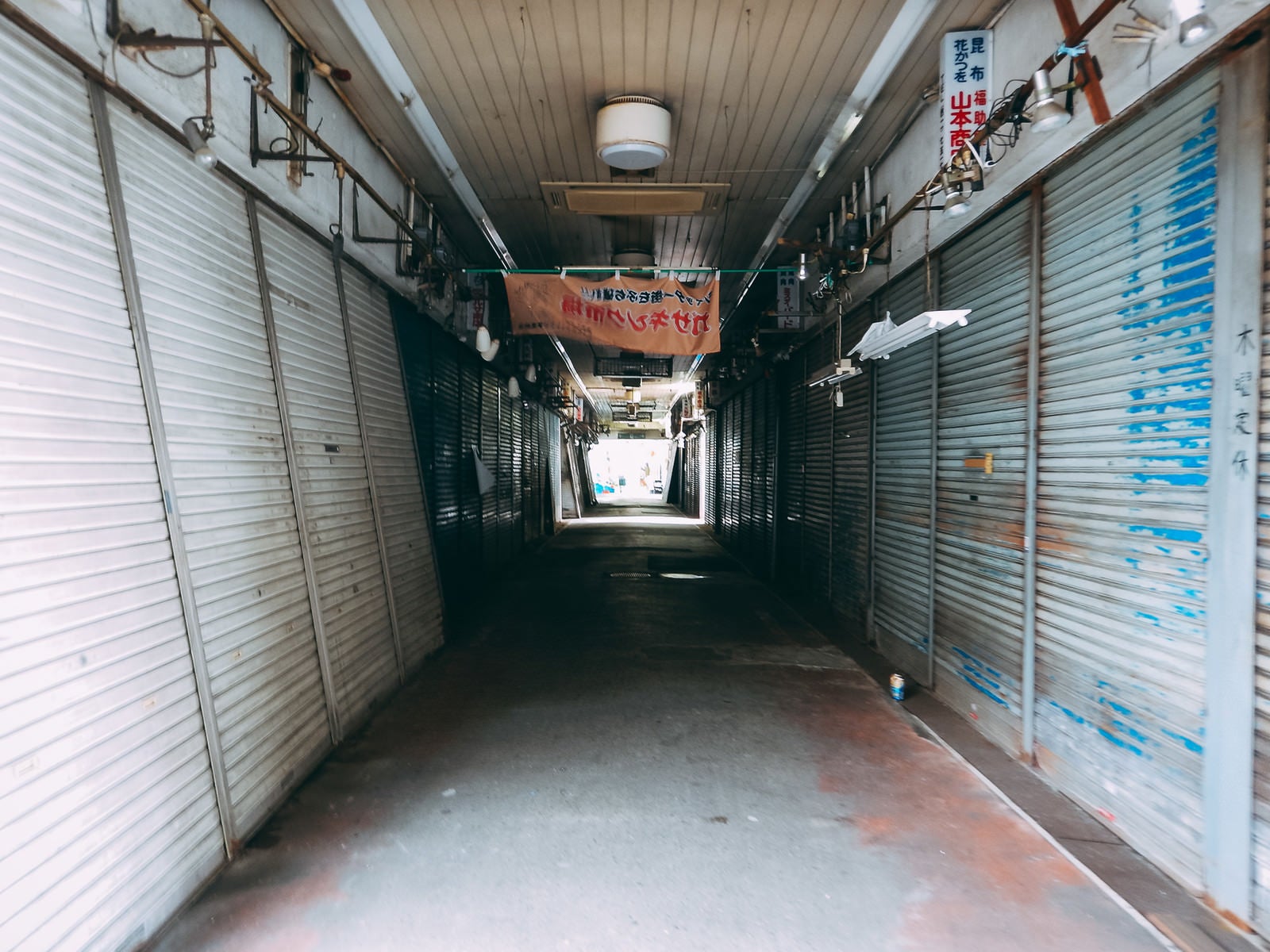 「三和市場（尼崎横丁）のシャッターで挟まれた通路」の写真