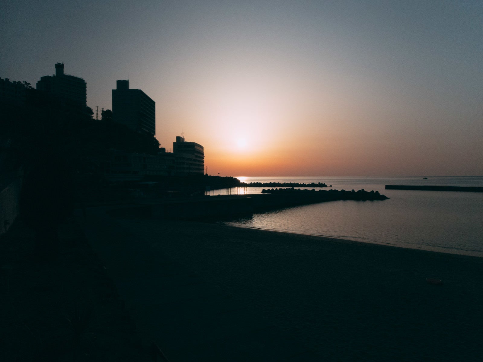 「熱海の夕日と街並みのシルエット」の写真