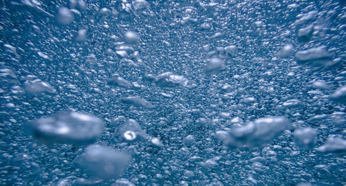 水中に浮かぶ無数の泡の写真