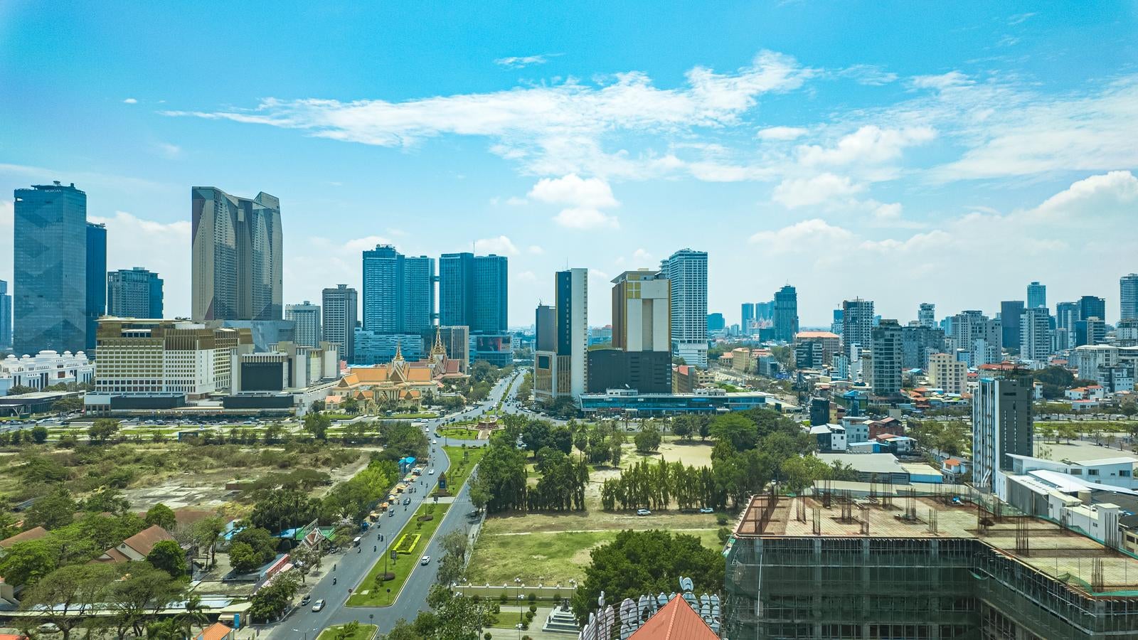 「カンボジア首都プノンペンの近代的な高層ビル群と緑豊かな都市公園」の写真