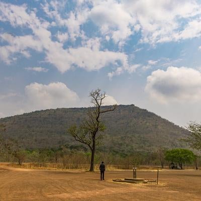 プレアヴィヒア寺院がある山を目の前にするスーツ姿の男性の写真