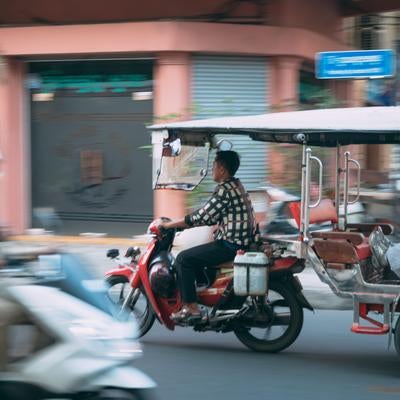 カンボジアの街中を走るバイクタクシーの素材