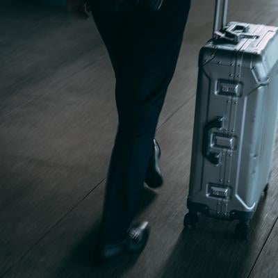 空港で荷物を運ぶ旅行者の様子の写真