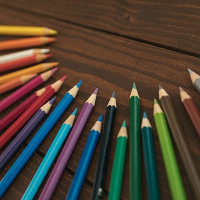 木目テーブルに並べられた色鉛筆の写真