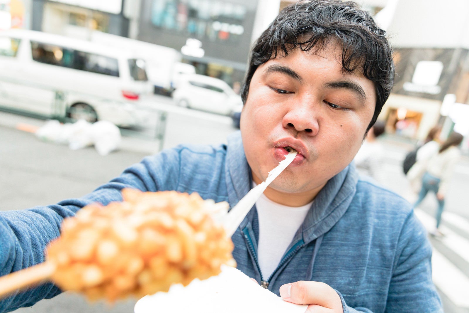 「チーズドッグを食す食いしん坊さん」の写真［モデル：段田隼人］