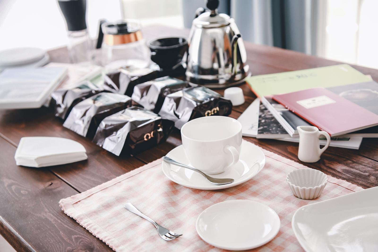 コーヒーカップとティーポットが置かれた木製テーブル