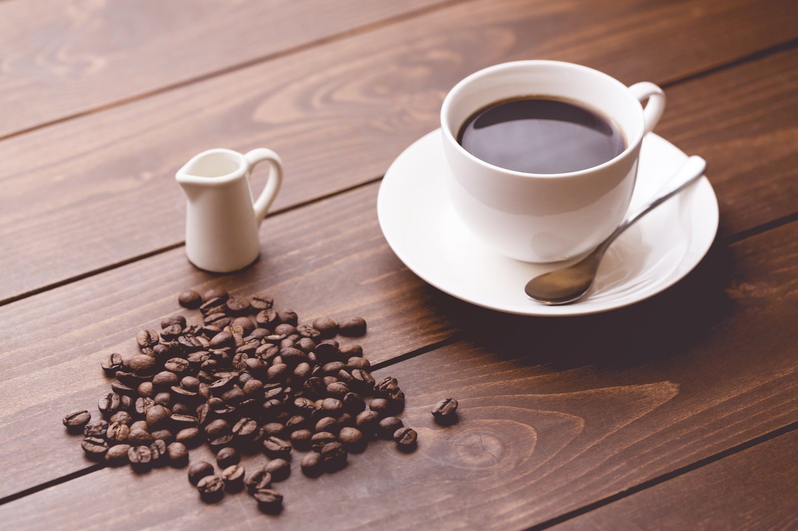 「コーヒー豆と淹れたてのコーヒー」の写真