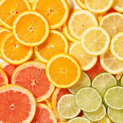 カットされて並んだグレープフルーツやライムなどの柑橘類の写真