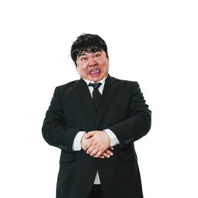 黒いスーツを着た男性が驚いた表情で腕組みの写真