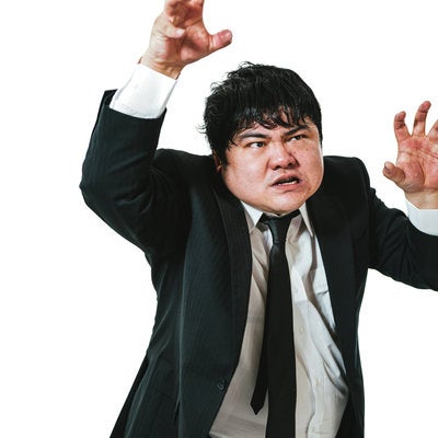 両手を使って威嚇する男性会社員の写真