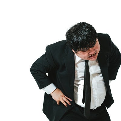 腰を折って脅し付ける男性会社員の写真