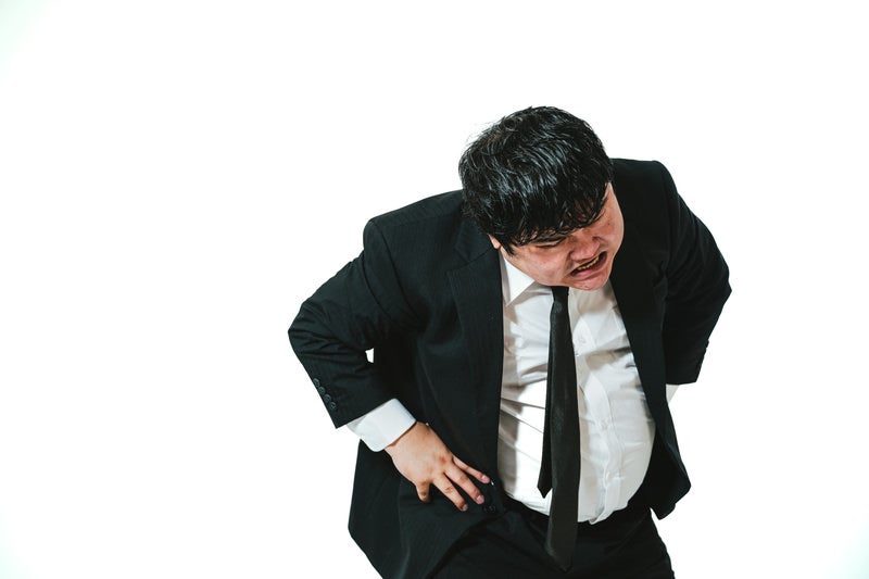 腰を折って脅し付ける男性会社員の写真