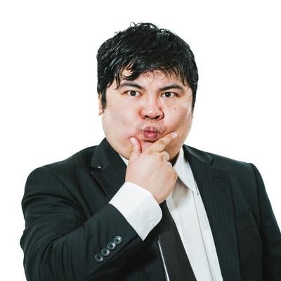 顎に手を当てて考え込むスーツ姿の男性の写真