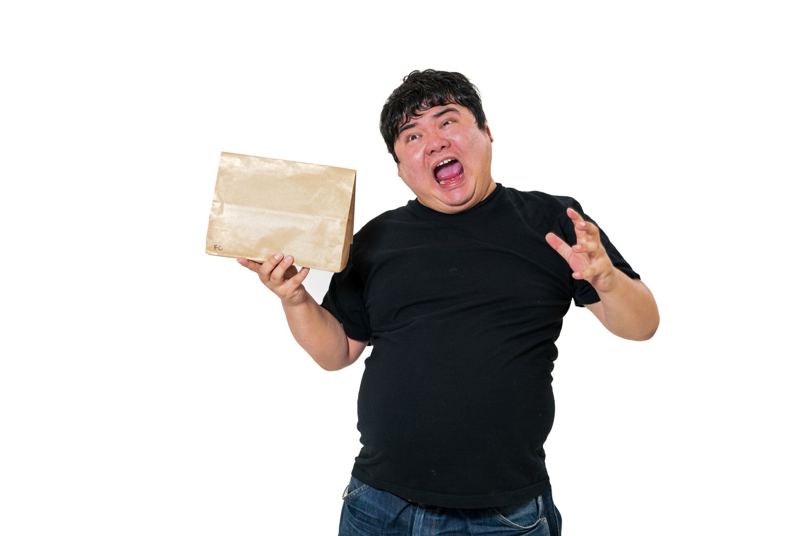 茶色い小包を持ちながら驚いた表情を見せる黒いTシャツの男性［モデル：段田隼人］