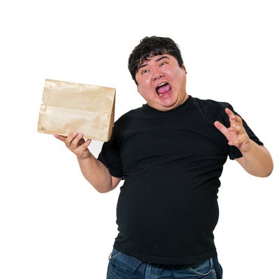 宅配物を持ったまま慌てふためく表情を見せる男性の写真