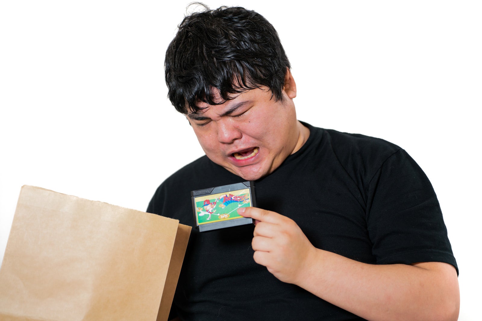 「レトロゲームガチャをする男性」の写真［モデル：段田隼人］