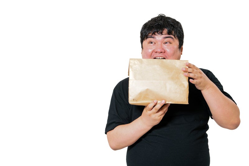 口を開けて紙包みを受け取る男性の驚き表情の写真