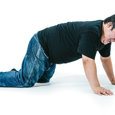 膝をついて立ち上がろうとする男性の写真
