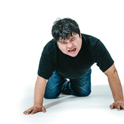 四つん這いで落ちた物を探す男性の写真