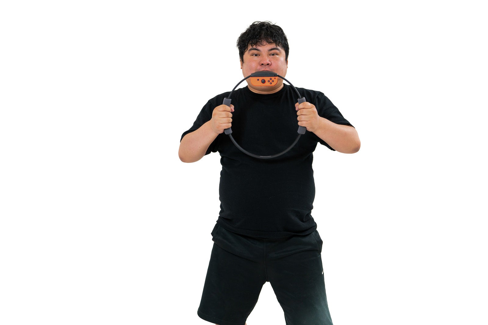 黒いTシャツを着た男性がリングコンを両手で握りしめている［モデル：段田隼人］