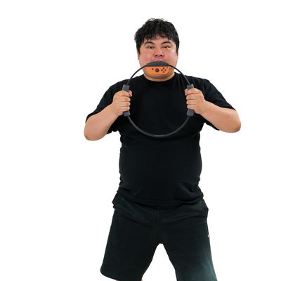 リングコンを両手で握りしめてエクササイズする男性の写真