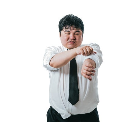 暑さで袖口を捲り上げる男性会社員の写真