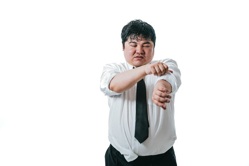 暑さで袖口を捲り上げる男性会社員の写真