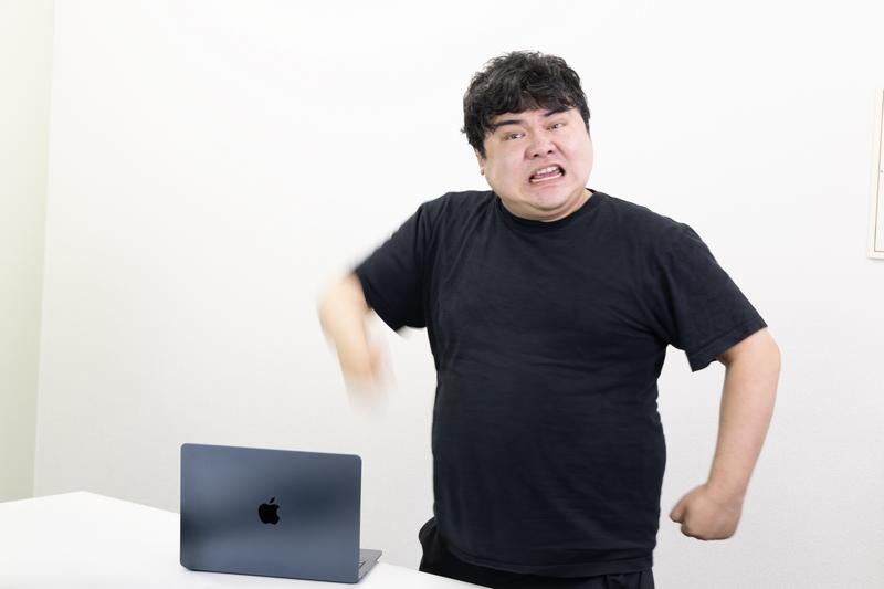 腕を振り下ろしてPCに怒りや苛立ちを叩く男性の写真