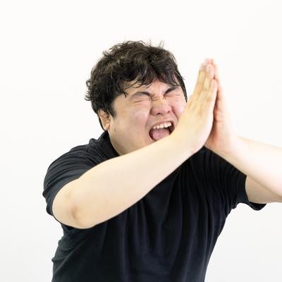 両手を合わせて懇願する男性の写真