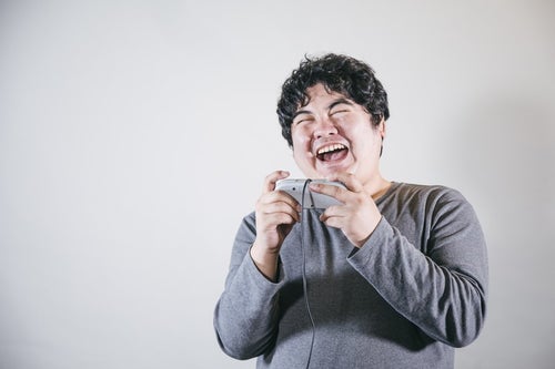 ゲームをしながら爆笑する男性の写真
