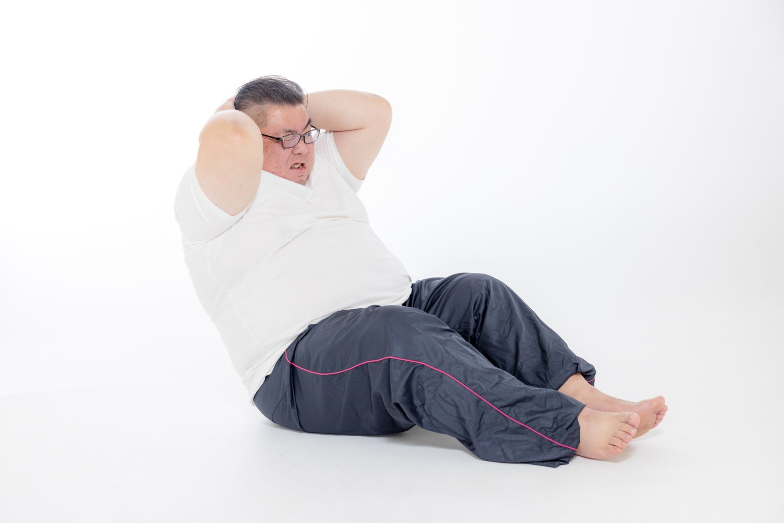 「腹筋を頑張ってみる100キロ以上の男性」の写真［モデル：ダルマ親方］