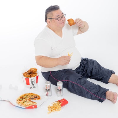 暴飲暴食する肥満男性の写真