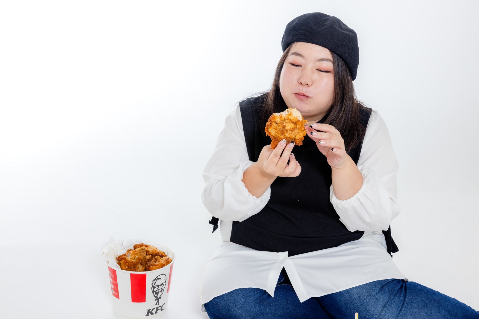 「フライドチキンを食べる女性」の写真［モデル：KANA］