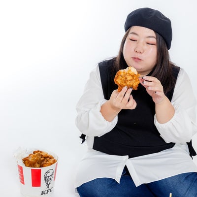 フライドチキンを食べる女性の写真