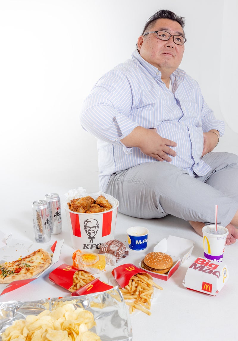 「出前で頼んで食べ過ぎた男性」の写真［モデル：ダルマ親方］
