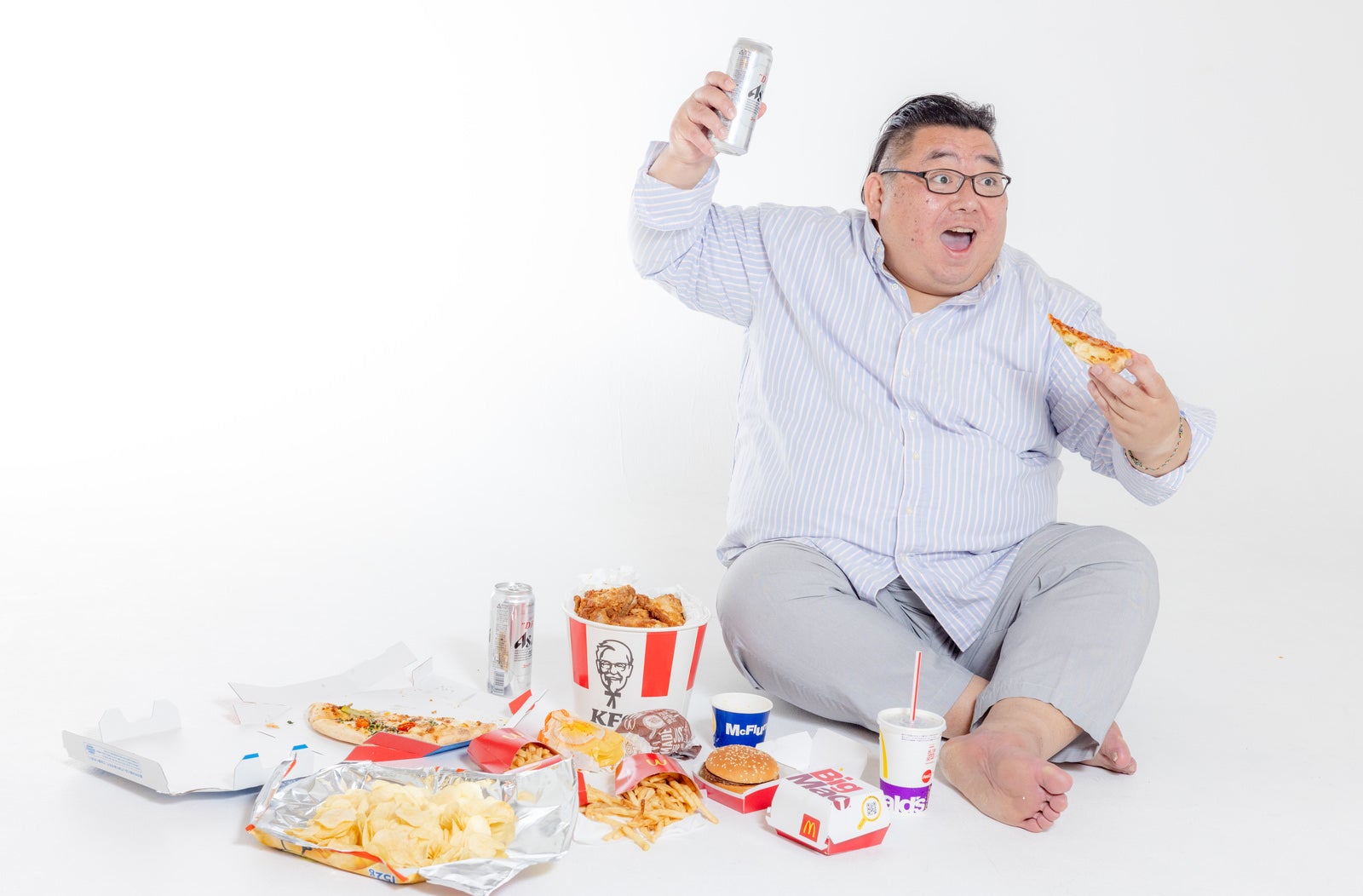 「ジャンクフードを食べながら観戦する肥満」の写真［モデル：ダルマ親方］