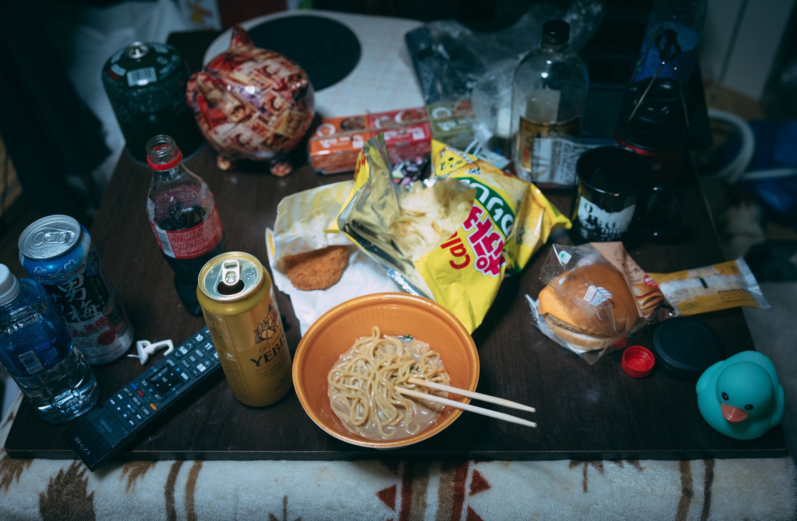 「散らかった部屋で食べる孤独飯」の写真