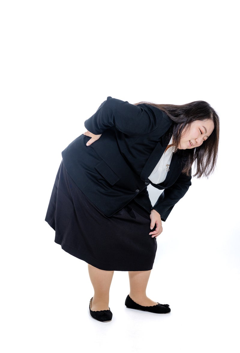 「腰を痛めた膨よかな女性」の写真［モデル：KANA］